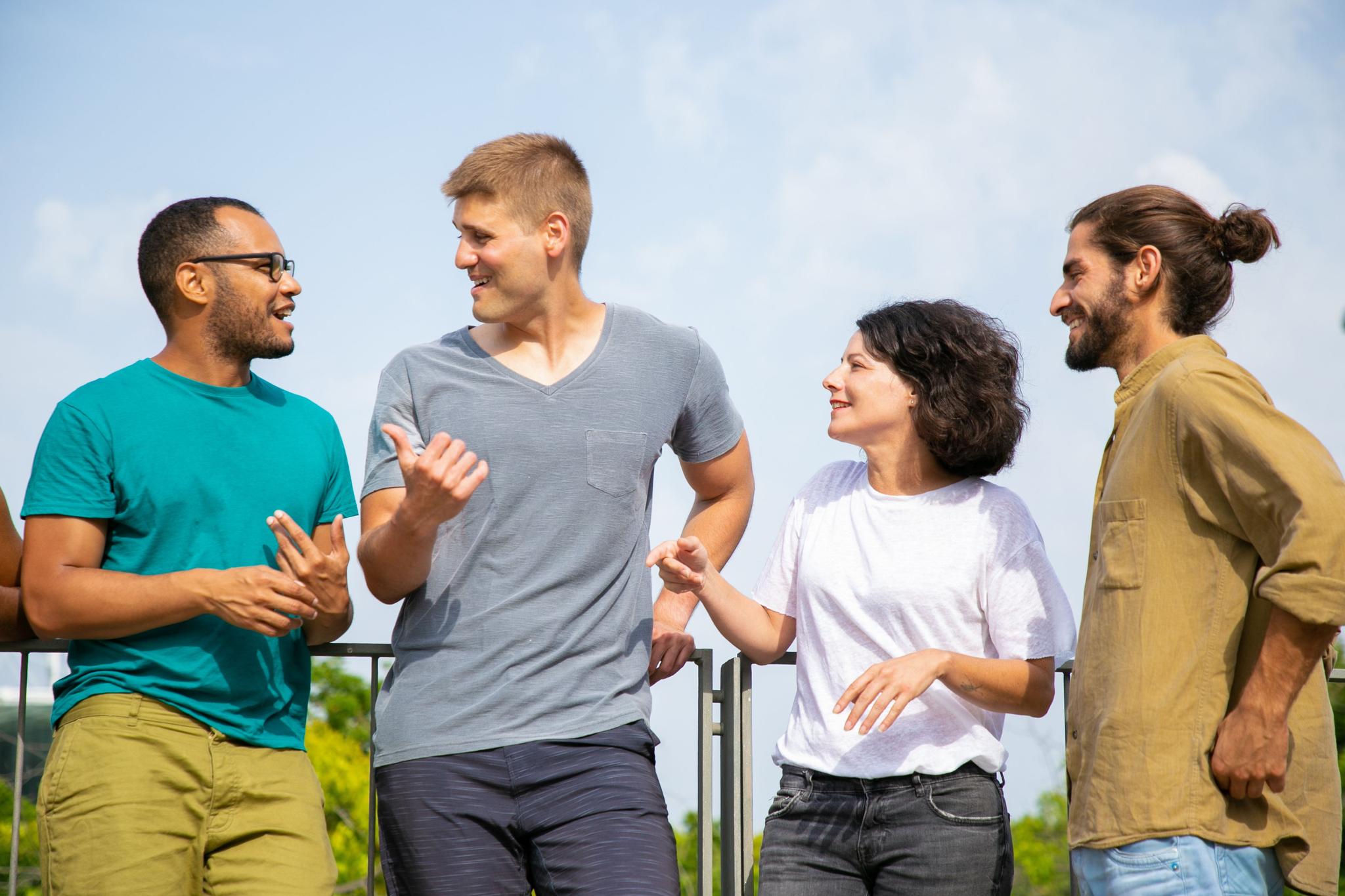 trois hommes et une femme qui discutent debout